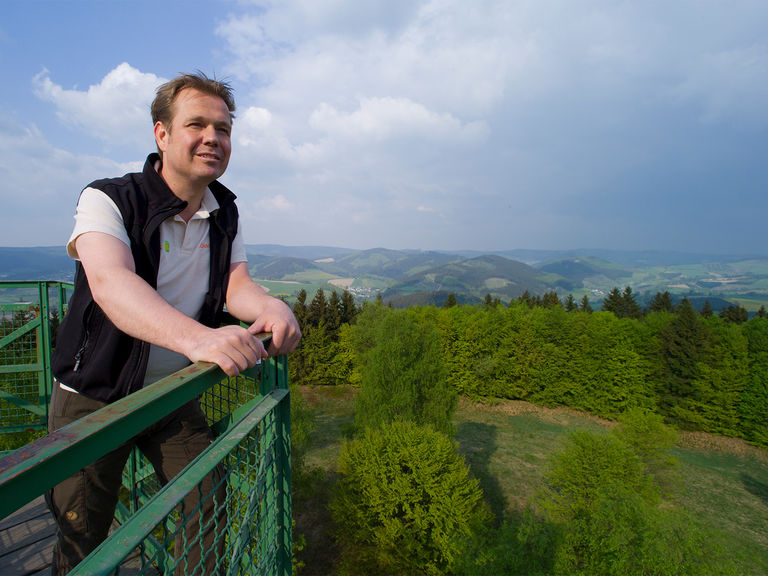 Ein Wanderer blickt über die Berge des Schmallenberger Sauerlandes